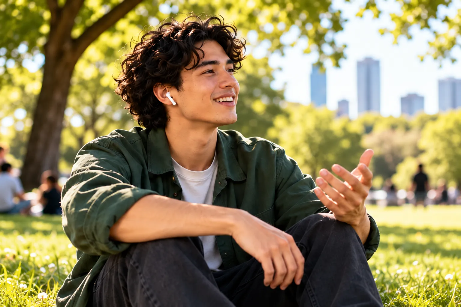 Young man with earbuds talking in a park